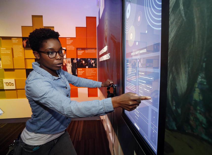 Nwaka Onwusa demonstrating how to use an interactive museum display